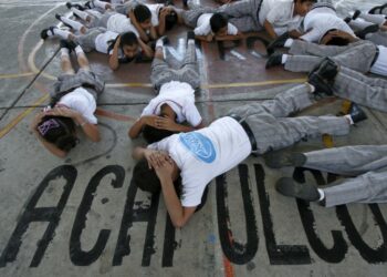 Elementary school students take part in a simulated shooting at the Felipe Carrillo Puerto school in Acapulco, on November 12, 2010. The Public Safety Department conducts training with students, parents and teachers in public and private schools of the state of Guerrero to take preventive measures against "violent acts".  AFP PHOTO/Pedro Pardo